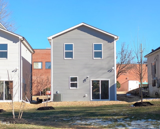 rear view of house featuring central AC and a yard