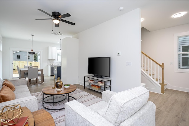 living room featuring ceiling fan and light hardwood / wood-style flooring