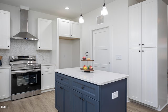 kitchen featuring pendant lighting, white cabinetry, blue cabinetry, wall chimney range hood, and stainless steel electric range