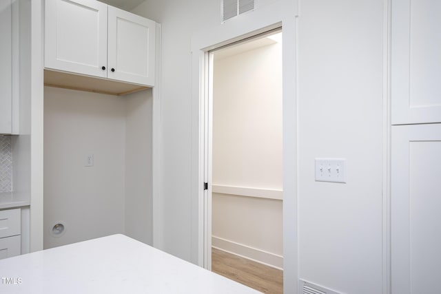 clothes washing area featuring light hardwood / wood-style flooring