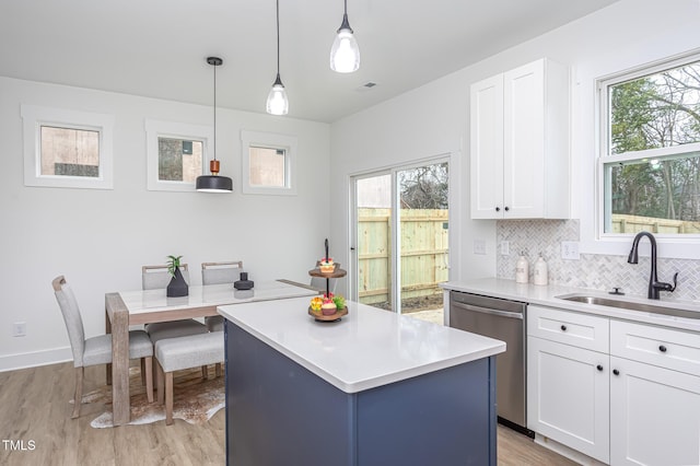 kitchen featuring a kitchen island, decorative light fixtures, sink, white cabinets, and stainless steel dishwasher