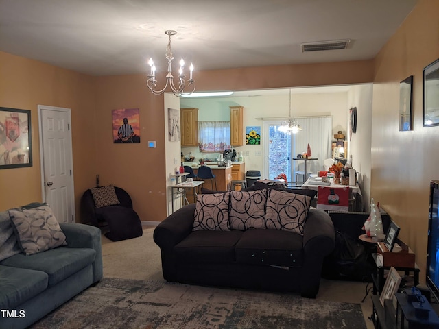 carpeted living room featuring a notable chandelier