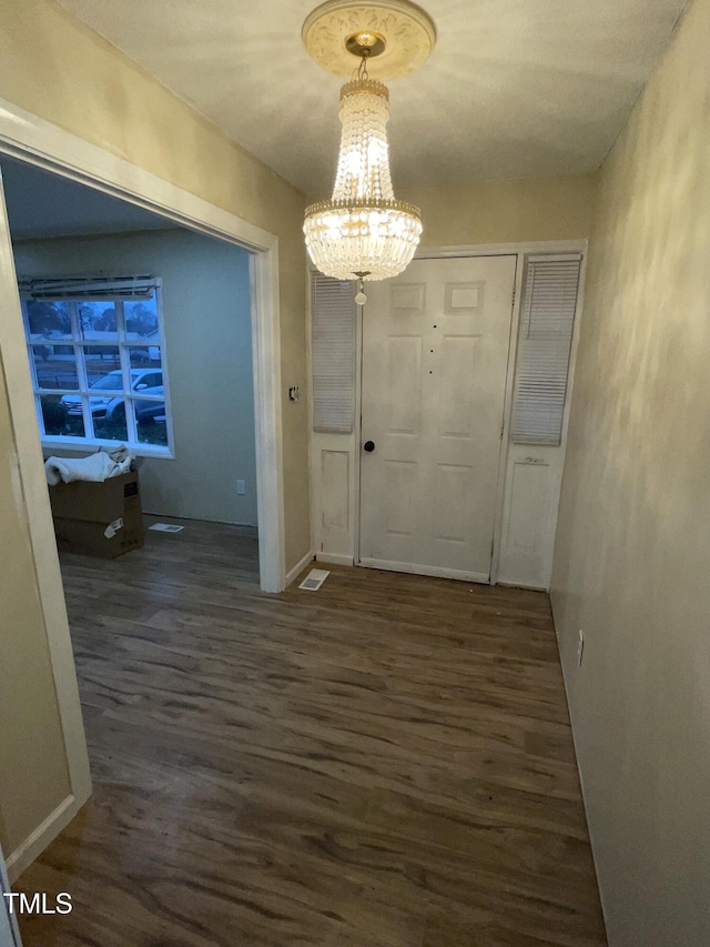 interior space featuring dark hardwood / wood-style flooring and a notable chandelier