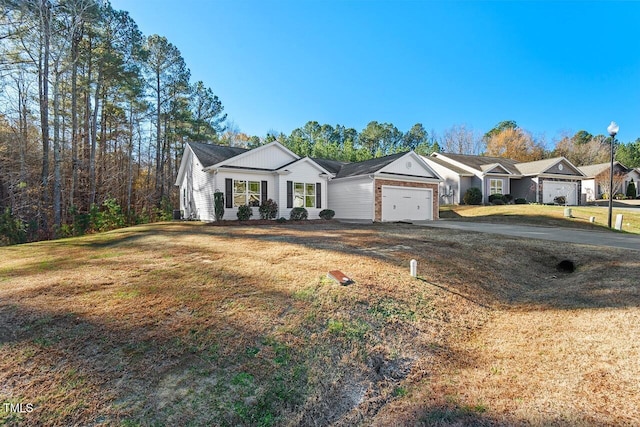 single story home featuring a garage and a front yard