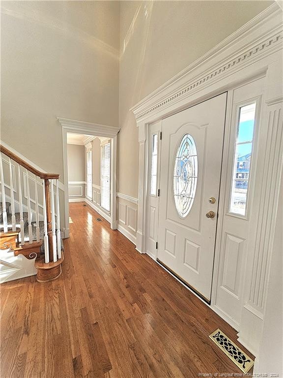 entrance foyer with hardwood / wood-style floors and ornamental molding