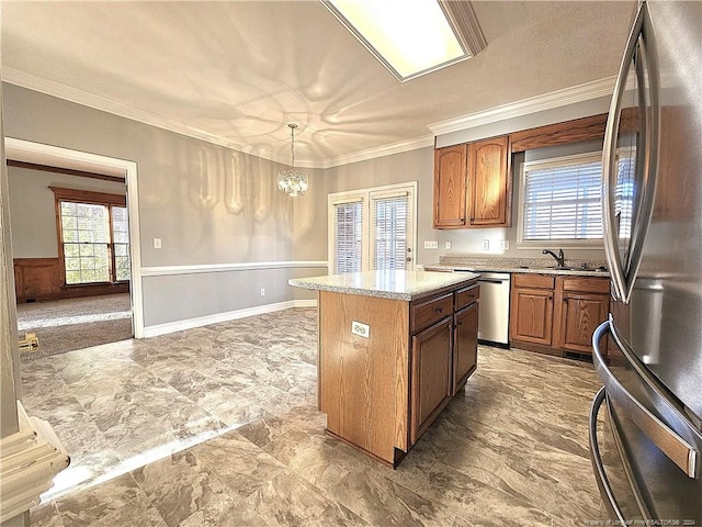 kitchen featuring appliances with stainless steel finishes, crown molding, decorative light fixtures, an inviting chandelier, and a kitchen island