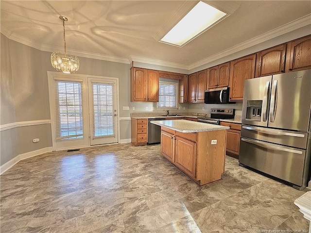 kitchen featuring pendant lighting, crown molding, appliances with stainless steel finishes, a notable chandelier, and a kitchen island