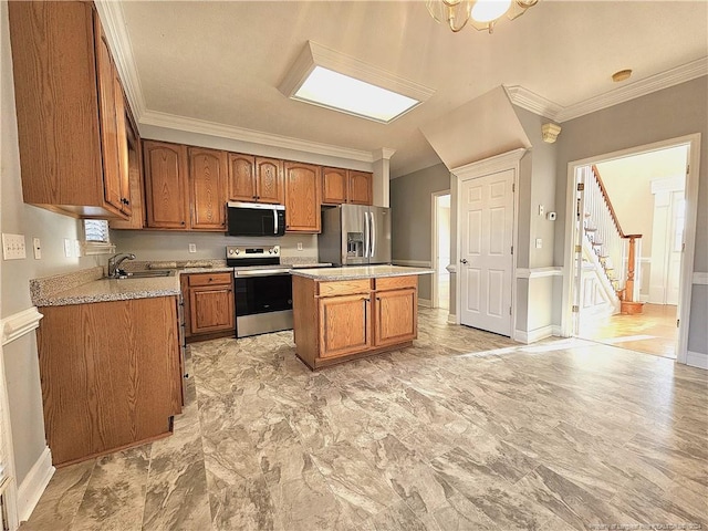 kitchen featuring sink, ornamental molding, appliances with stainless steel finishes, a notable chandelier, and a kitchen island