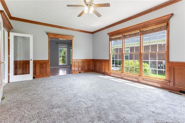 carpeted spare room featuring ceiling fan, crown molding, and french doors