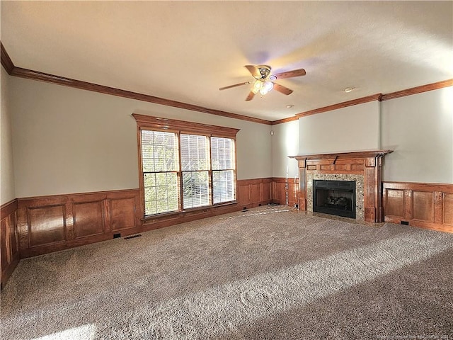 unfurnished living room with crown molding, carpet floors, and ceiling fan