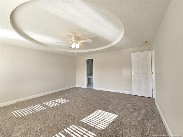 carpeted spare room featuring a textured ceiling, a raised ceiling, and ceiling fan