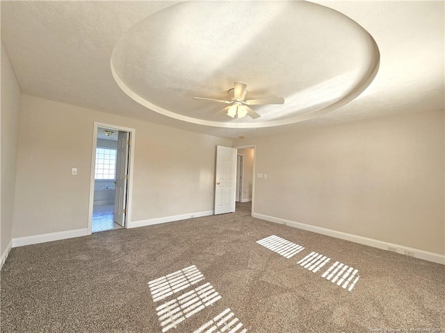 unfurnished room featuring carpet flooring, a raised ceiling, and a textured ceiling