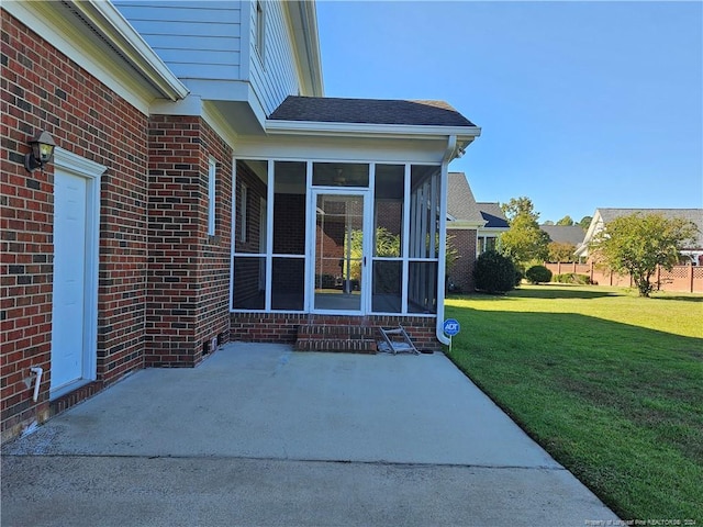 property entrance with a lawn and a patio area