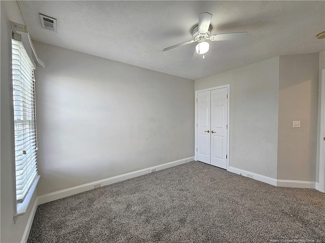 carpeted spare room with ceiling fan and a textured ceiling