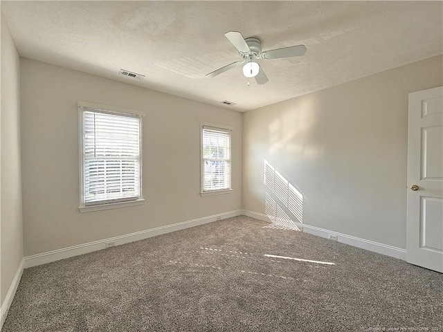 carpeted spare room featuring ceiling fan and a textured ceiling