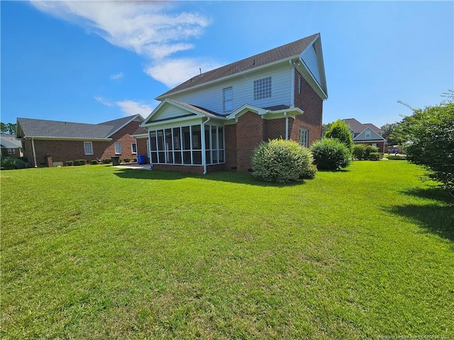 back of house featuring a sunroom and a yard