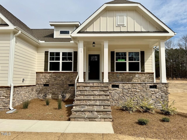 view of front of house with stone siding, a porch, and board and batten siding