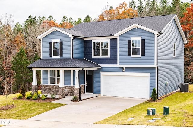 view of front of home with central AC unit, a garage, covered porch, and a front yard