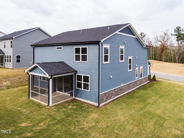 back of house featuring a yard and a sunroom