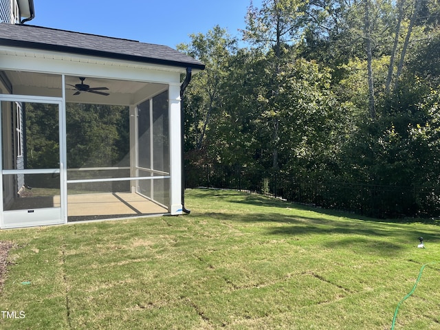 view of yard with ceiling fan and a sunroom