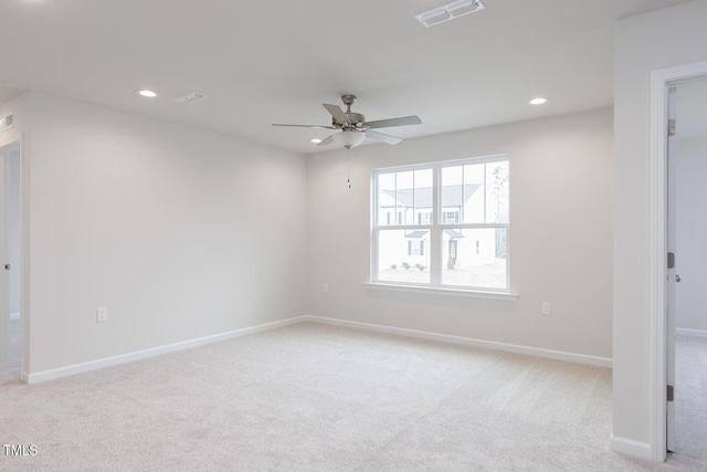 spare room featuring light carpet and ceiling fan