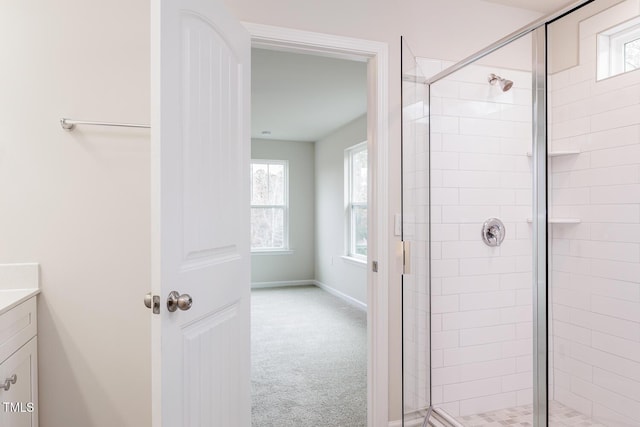 bathroom featuring vanity, a shower with door, and a wealth of natural light