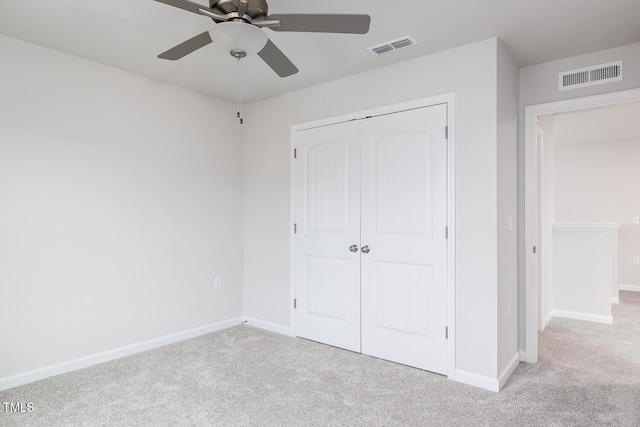 unfurnished bedroom featuring ceiling fan, light carpet, and a closet