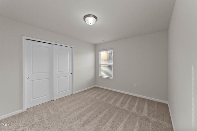 unfurnished bedroom with carpet floors and a closet