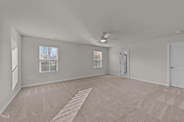 spare room with ceiling fan and light colored carpet