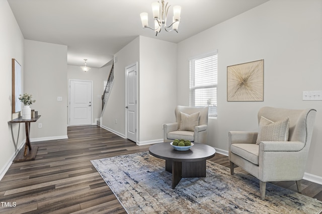 living area with dark hardwood / wood-style floors and a notable chandelier