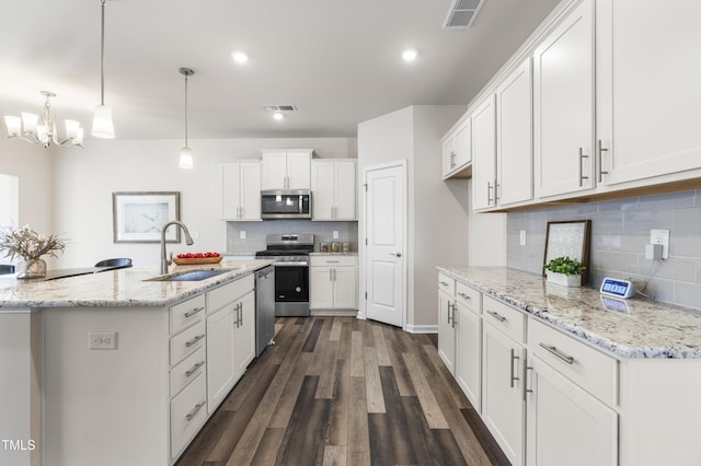 kitchen featuring dark hardwood / wood-style floors, pendant lighting, sink, stainless steel appliances, and white cabinets