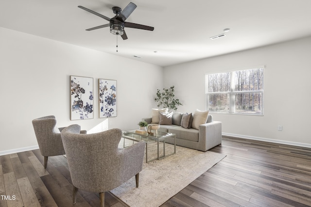 living room featuring ceiling fan and dark wood-type flooring