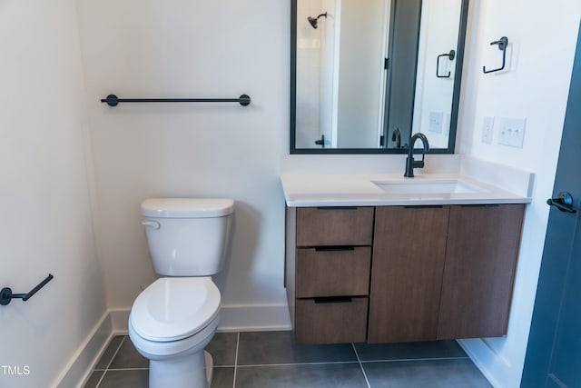 bathroom with toilet, vanity, and tile patterned floors