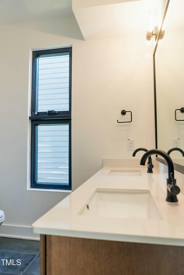 bathroom featuring tile patterned floors, vanity, and a healthy amount of sunlight