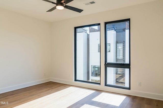 spare room with hardwood / wood-style flooring, plenty of natural light, and ceiling fan