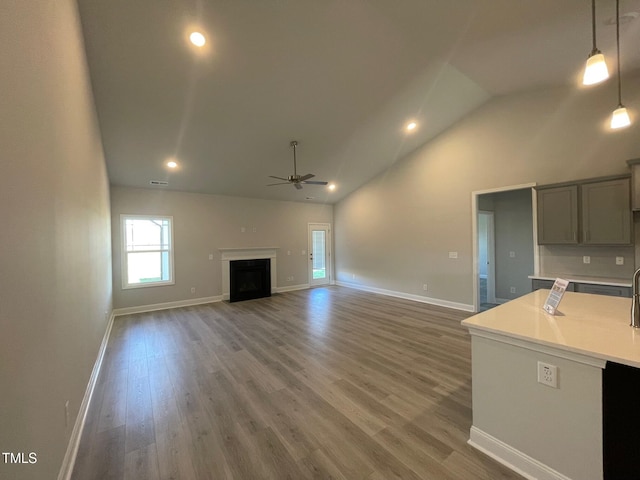 unfurnished living room featuring high vaulted ceiling, ceiling fan, and dark hardwood / wood-style flooring