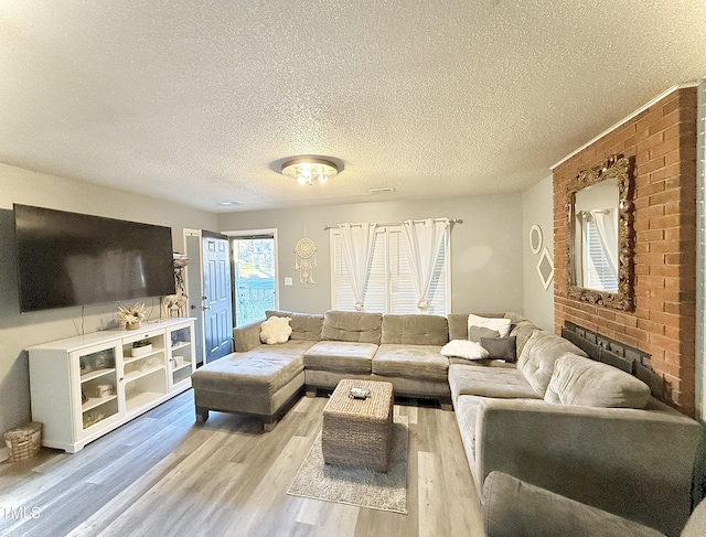 living room featuring light hardwood / wood-style floors and a textured ceiling