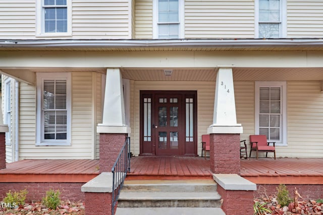 view of exterior entry featuring covered porch