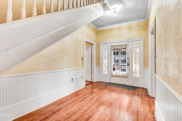 entryway featuring wood-type flooring and crown molding