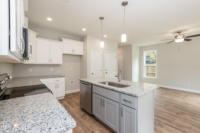 kitchen with white cabinets, stainless steel appliances, and an island with sink