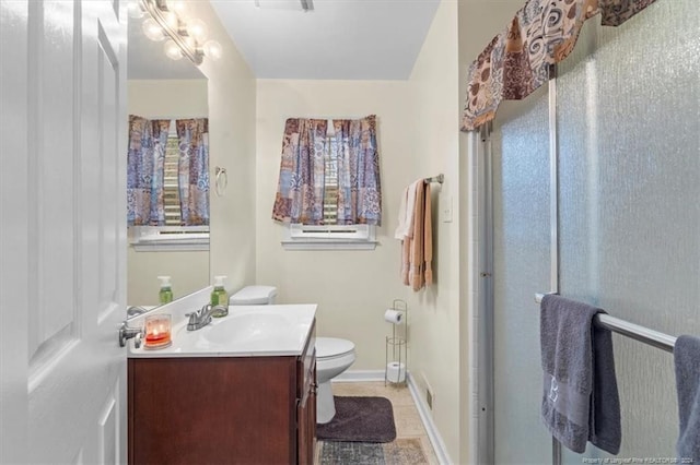 bathroom with tile patterned floors, vanity, toilet, and walk in shower