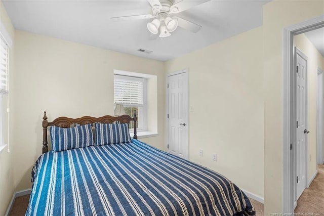 bedroom with ceiling fan and light carpet