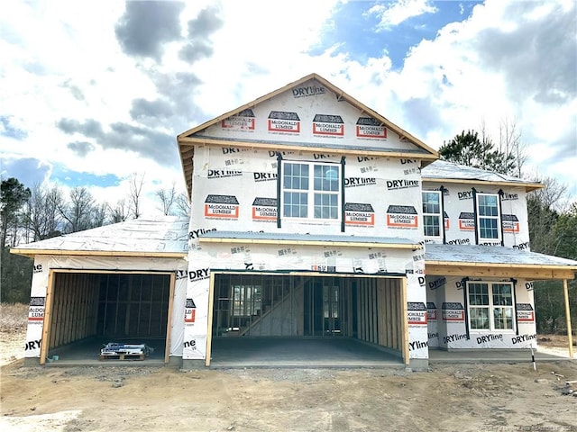 unfinished property featuring a garage and driveway