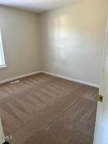 empty room with dark colored carpet