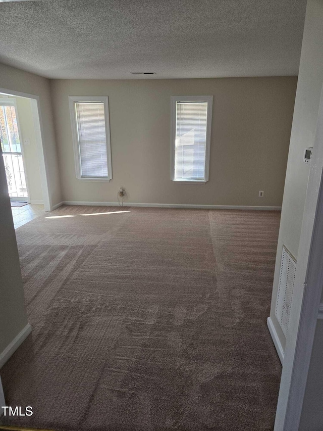 carpeted spare room featuring a textured ceiling