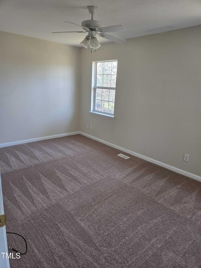 carpeted empty room with ceiling fan and a textured ceiling