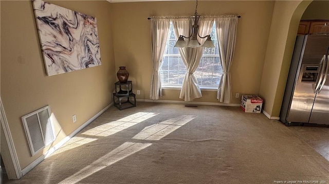 unfurnished dining area with light carpet and a chandelier