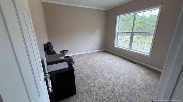 carpeted spare room featuring baseboards, ornamental molding, and visible vents