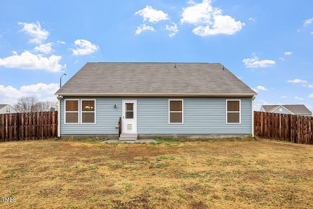 rear view of house featuring a yard