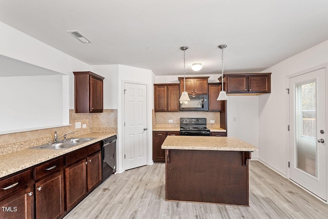 kitchen featuring pendant lighting, sink, light hardwood / wood-style flooring, and black appliances